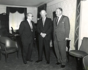 Two men standing and posing with US President Eisenhower