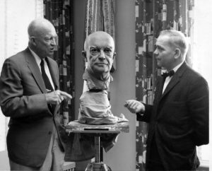 Two men gathered around bust